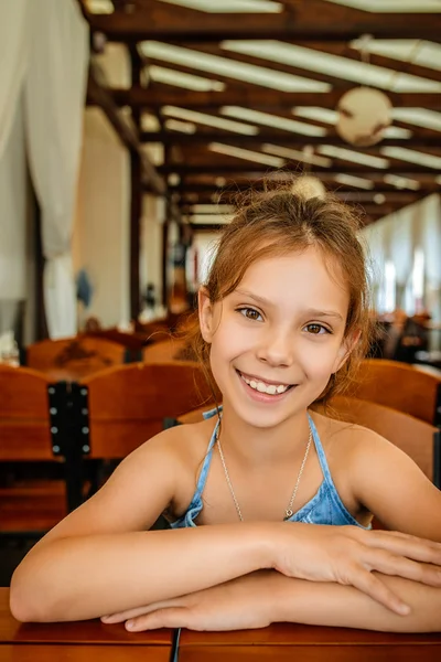 Little beautiful cheerful girl in restaurant