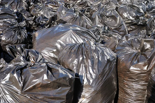 Pile of black garbage bags with tons of trash, horizontal
