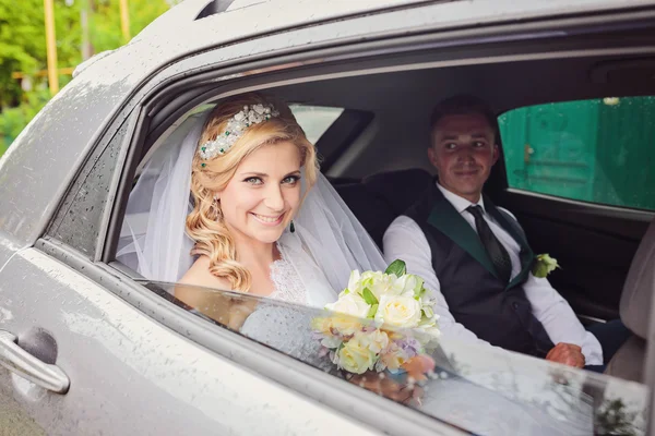 Portrait of pretty shy bride in a car window