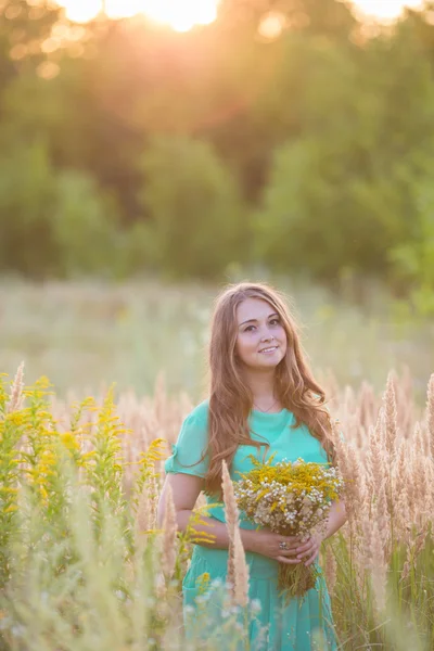 Artistic portrait of young gorgeous brunette on green meadow.