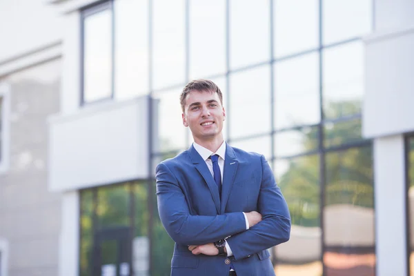Portrait of a young businessman standing over blurred background