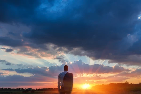 Happy farmer, businessman, standing in field with his hands and thumbs up