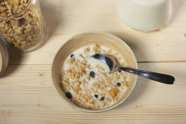 Delicious and healthy cereal in bowl with milk on table
