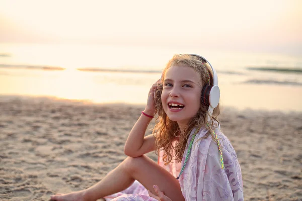 Youth girl listens to music on the beach