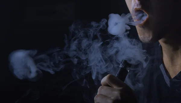 Man smoking electronic cigarette and Making Smoke Rings