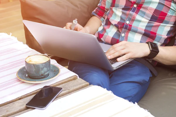 Cropped image of stylish man with laptop and coffee. Modern lifestyle