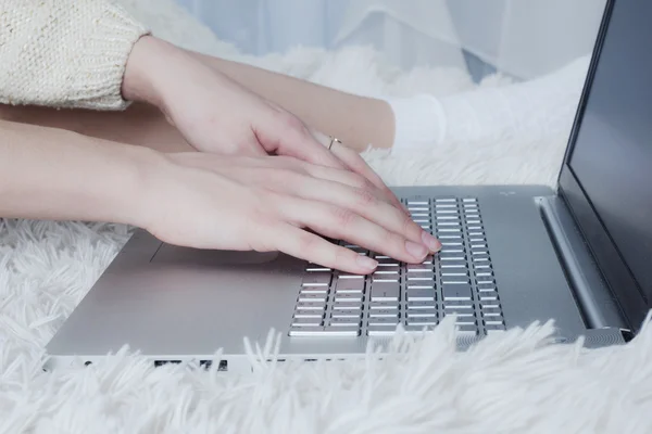 Girl\'s hands to print text on a laptop