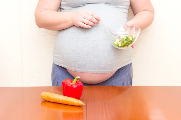 Pregnant woman eating salad. Diet for pregnant women.