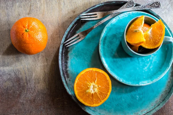 Orange fruits on turquoise plate