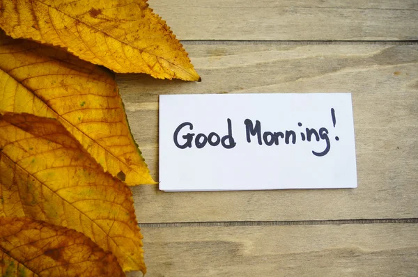 Yellow leaves on the wooden background