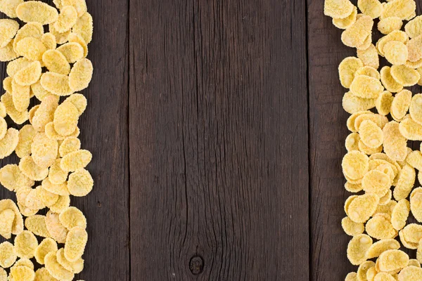Corn flakes on old wooden table.