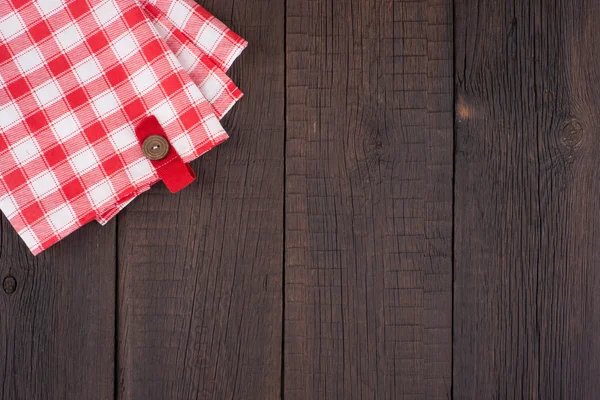 Rustic wooden boards with a red checkered tablecloth.