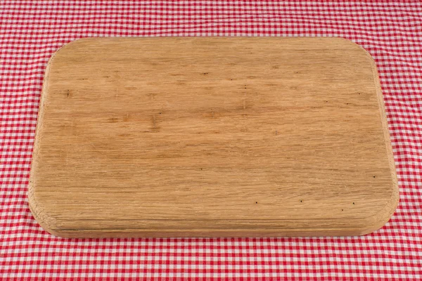 Wood cutting board on tablecloth