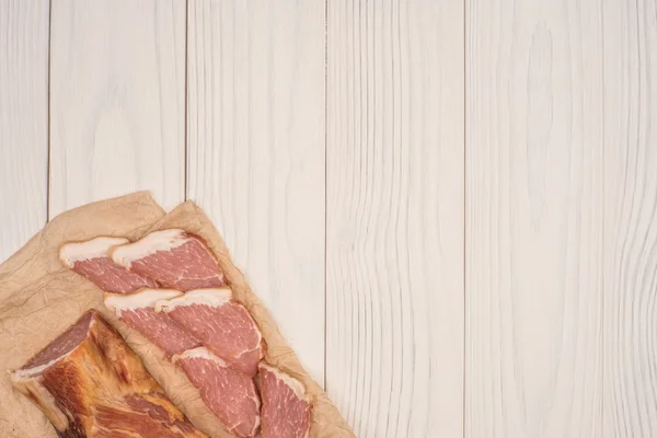 Smoked meat on a white wooden table.