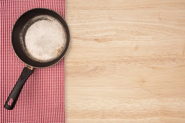 Empty pan on wooden deck table with tablecloth. Flat mock up for