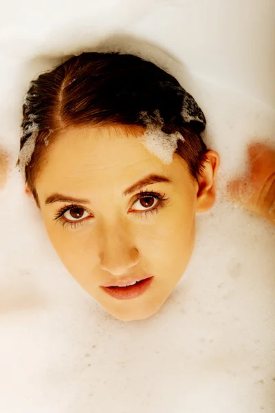 Young woman washing hair in bath