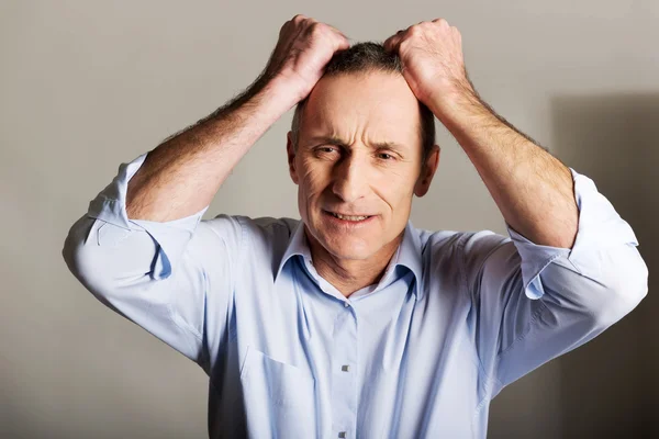 Portrait of frustrated man pulling his hair