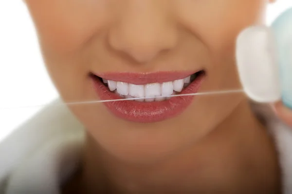 Woman using dental floss.