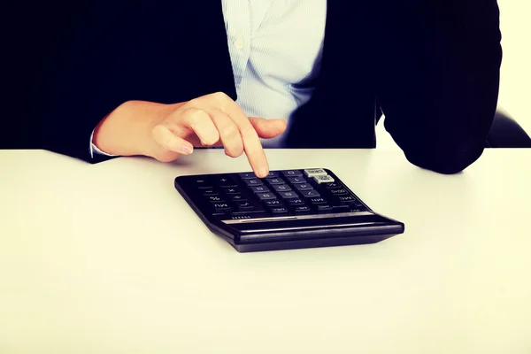 Business womans hands counts on the calculator