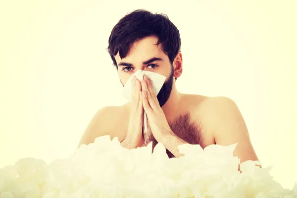 Sick man sneezing into handkerchief.