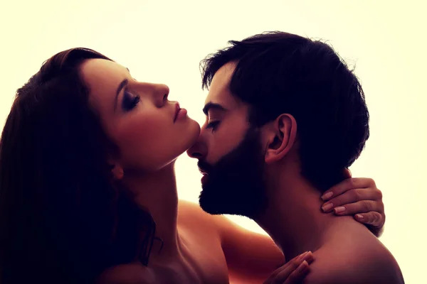 Caucasian man kissing womans neck.