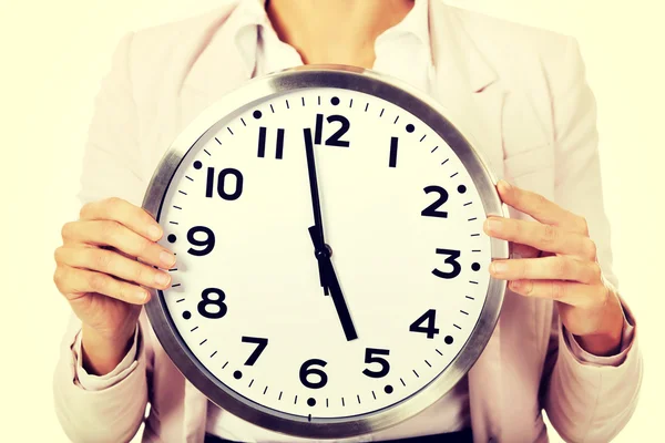 Young business woman holding office clock