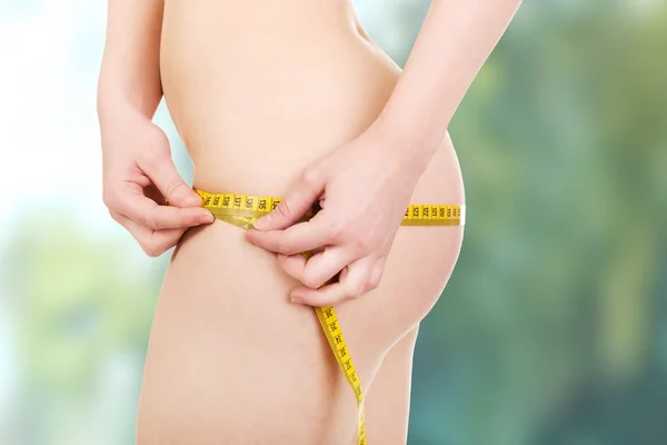 Slim woman measuring her hips. - Stock Image - Everypixel
