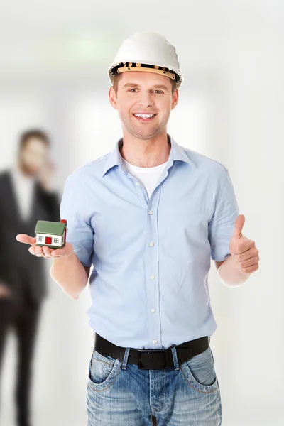 A forewoman holding a model house