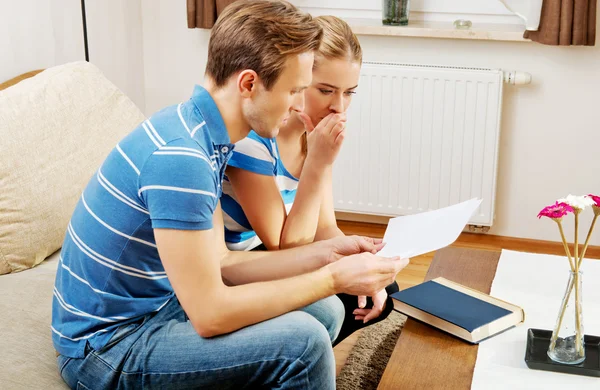 Young couple examining plans of apartment