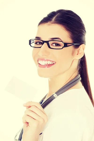 Young female doctor holding business card.