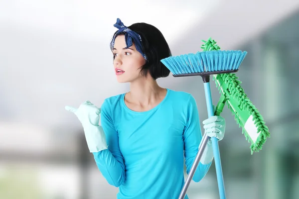 Happy cleaning woman showing copy space.