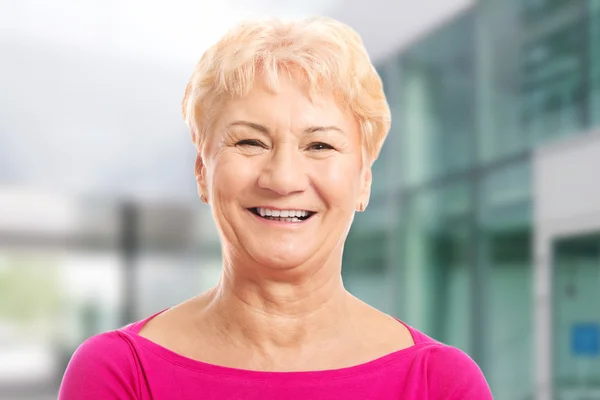 Portrait of an old woman in pink shirt.