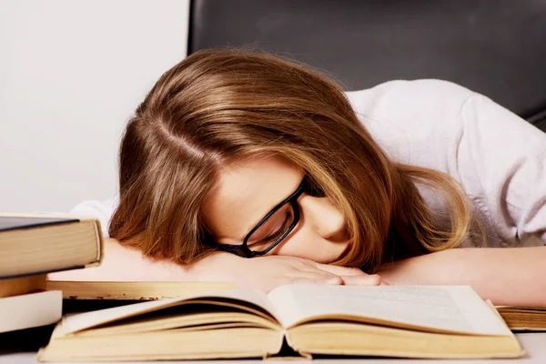 Tired woman with a books pile