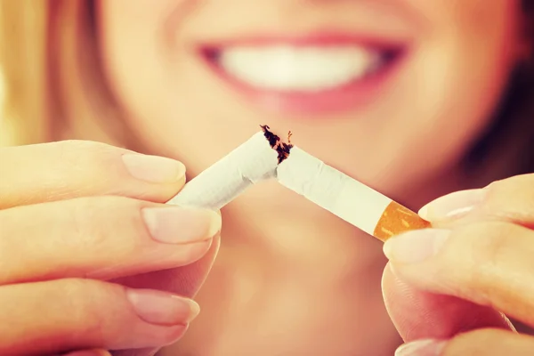 Woman holding broken cigarette