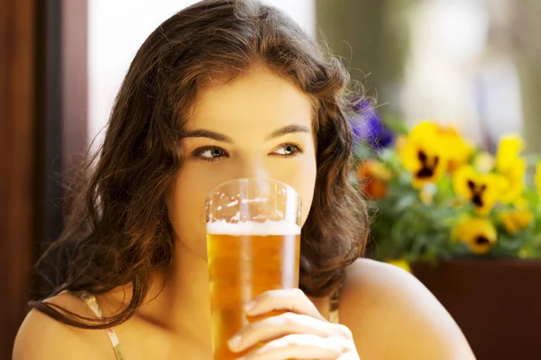 Woman drinking beer in bar