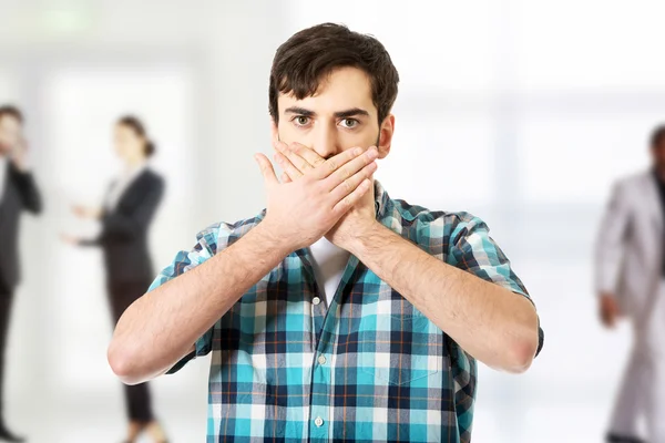 Shocked man covering mouth.