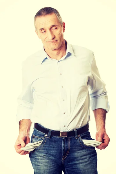 Confused man showing his empty pockets