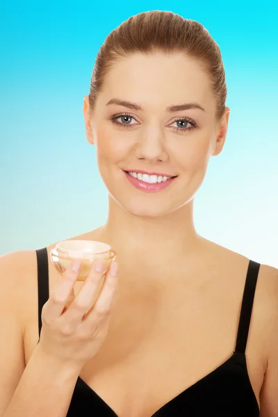 Woman applying cream moisturizer.