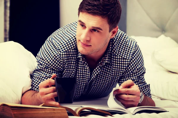 Thoughtful man with a book in his bed.