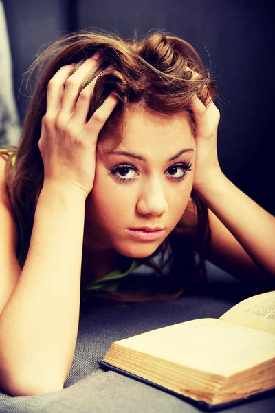Young woman learning to exam on a sofa.