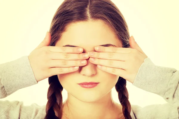 Teen woman covering her eyes.