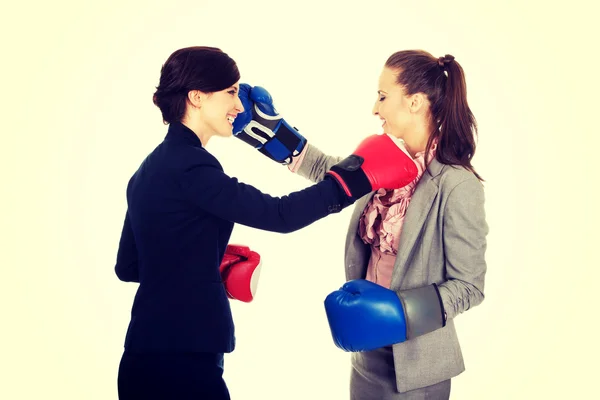 Two business women with boxing gloves fighting.