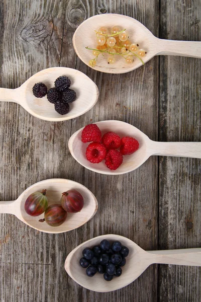 Different ripe berries in a spoons