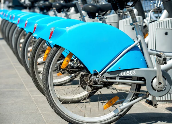 Row of blue rental bikes in city