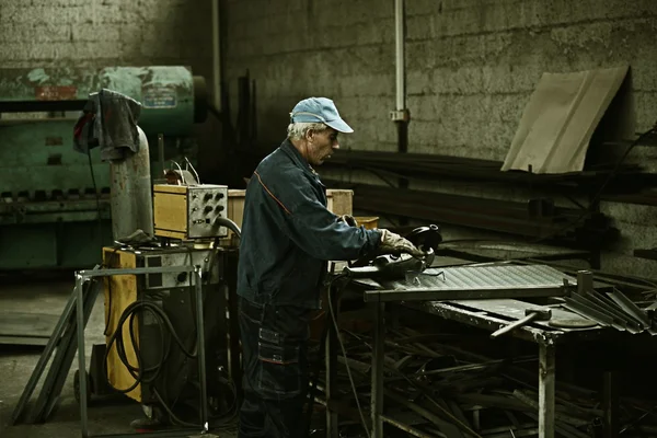 Worker cutting iron with professional tool