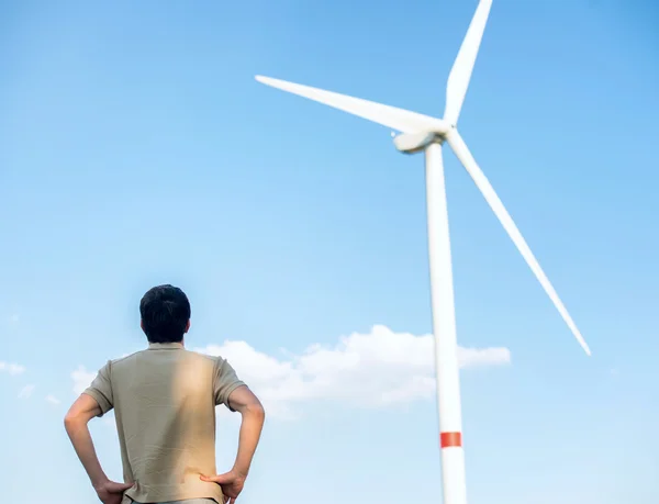 Man looking at wind turbine