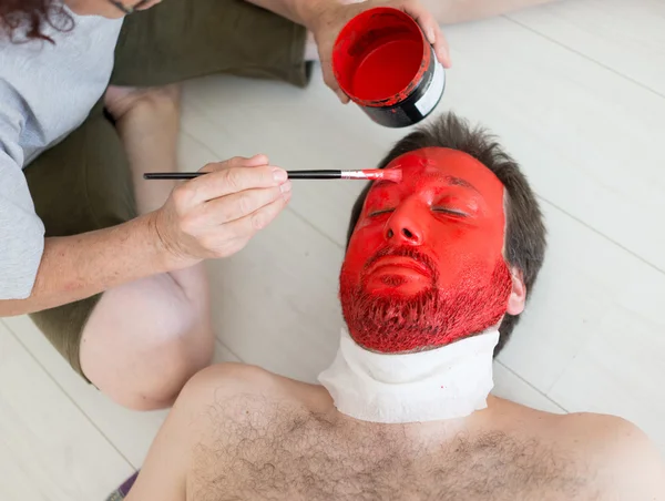 Painting in red man\'s face