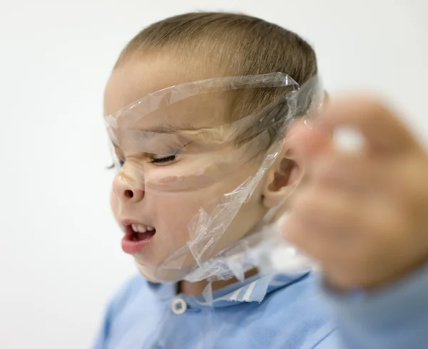 Funny two years old boy with tape on his face