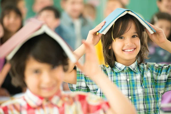 Children with books on heads