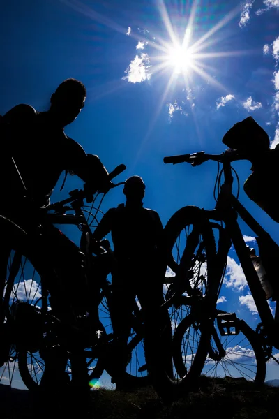 Biking group at sunset sky background.